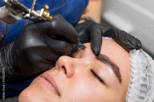 Cosmetic procedures for the treatment of eyebrows. Microblading in the beauty salon. Professional cosmetology. The process of applying the pigment shaping eyebrows.permanent makeup eyebrows  tattooing