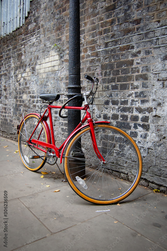Red bicycle with gray brick wall background in Candem, London Red bicycle with gray brick wall background in Candem, London