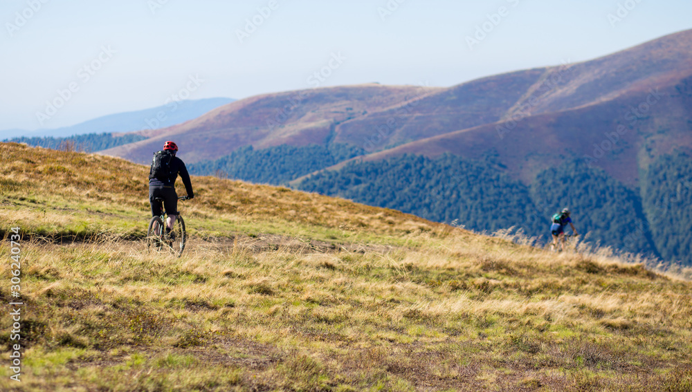 Young bright sport man ride on bike by top of mountains