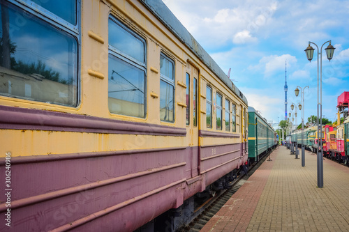 yellow-red train carriage, old carriage on the platform, side view of the train carriage, windows on the train