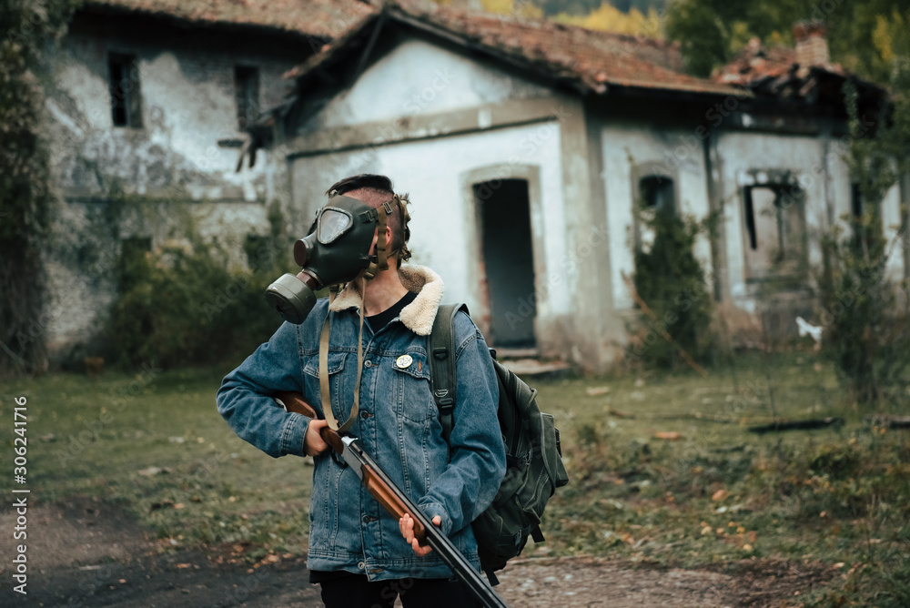Naklejka premium woman with gas mask, backpack and double barrel shotgun. post-apocalyptic, military and airsoft war games concept.