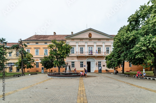 Kikinda, Serbia - July 26, 2019: National Museum building and beautiful fountain with sculpture "Family" in Kikinda, Serbia