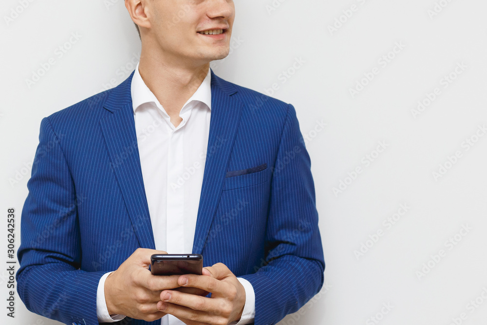 Young business man using his mobile device in business. Modern young guy with a phone in hand. Social networks business. Handsome man work on phone. Happy handsome guy browsing with his device. Young business man using his mobile device in business. Modern young guy with a phone in hand. Social networks business. Handsome man work on phone. Happy handsome guy browsing with his device.
