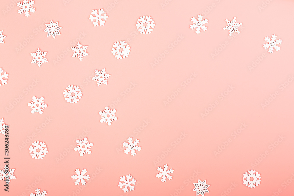 Gently pink winter background with white snowflakes. Creative christmas layout. Minimalistic Scandinavian style. Empty space for text, top view, flat lay Gently pink winter background with white snowflakes. Creative christmas layout. Minimalistic Scandinavian style. Empty space for text, top view, flat lay