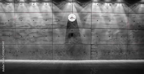 Raw concrete wall with a clock mounted photo