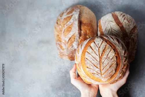 Sourdough bread. Freshly baked organic wheat bread. Child holding fresh round bread. photo