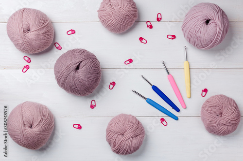 Woolen skeins of thread on white boards. ball of thread from Italian Angora. A knitting project is underway. A piece of knitting with a ball of yarn and knitting needles.