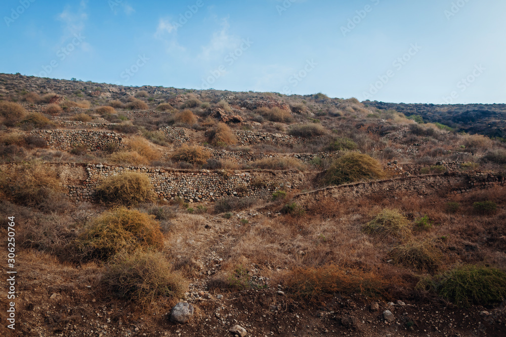 Santorini island autumn hills. Volcano soil natural landscape. Rows of stones.