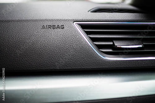 3-D Engraved Airbag Symbol Lettering Bottom Frame Left in Grainy Textured Black Dashboard with Air conditioning system. Interior details. © Anna