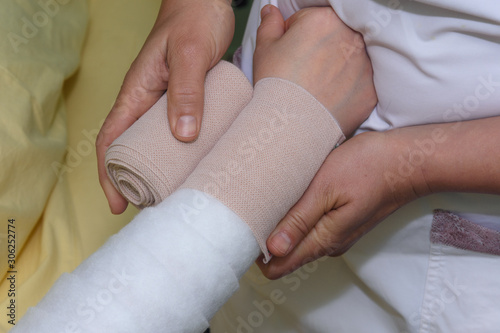 Fotografia Lymphedema management: Wrapping Lymphedema Hand and Arm using multilayer bandages to control Lymphedema