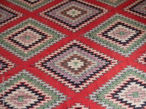 Close Up of a Kilim Rug with Geometric Pattern with Red Background