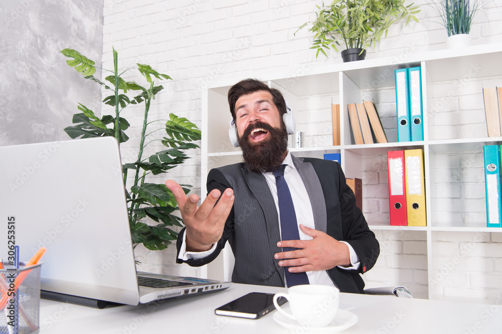 Naklejka premium Cant resist music. Businessman enjoy music in office. Bearded man listen to music and sing along to song. Insurance agent wear headphones playing music. Modern life. New technology