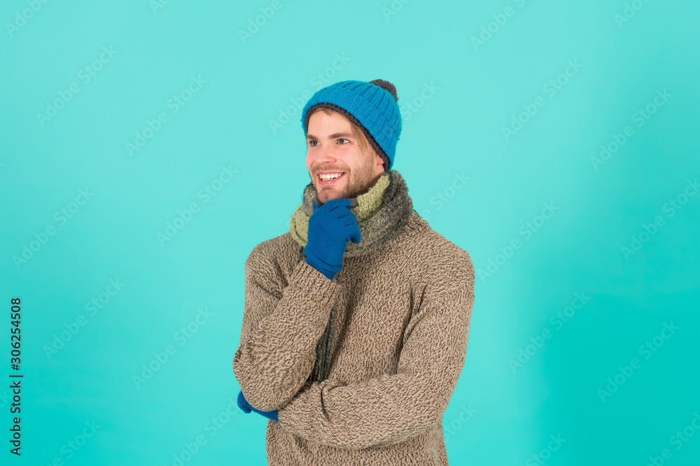 Carefree and happy. Man handsome unshaven guy wear winter accessories on blue background. Winter season sale. Hipster knitted winter hat scarf and gloves. Shopping concept. Emotional expression