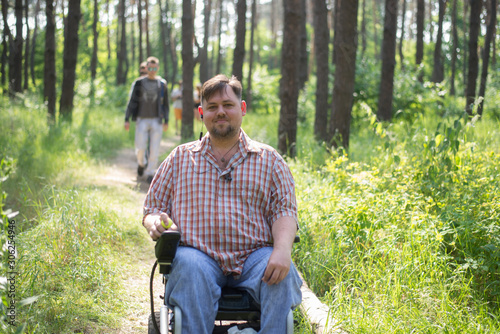 man in a wheelchair in a forest photo