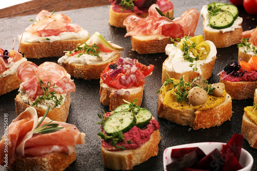 Assorted bruschetta with various toppings. Appetizing bruschetta or brie crostini. Variety of small sandwiches. Mix bruschetta on table