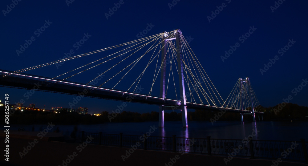 Obraz premium glowing bridge over the river in the night city