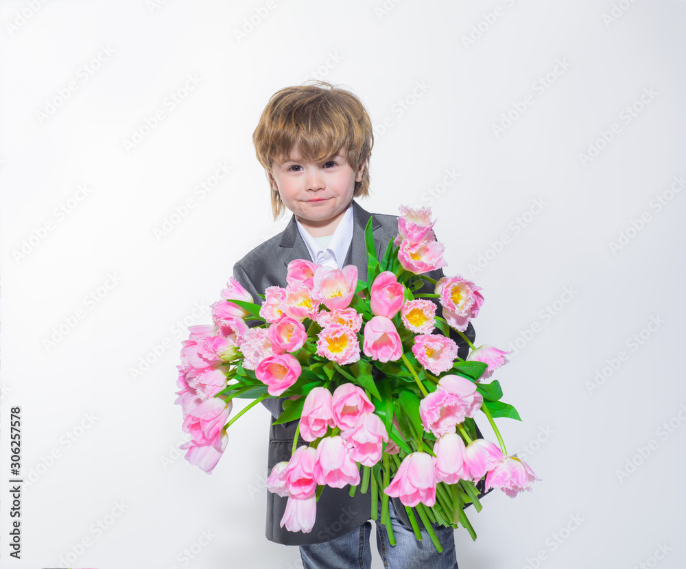 Smiling elegant little boy with bouquet of tulips. Gift to mum. Flower gift. Stylish little boy in elegant suit hold bouquet tulips. Birthday, Womens Day, Mothers Day, Valentines day. Wedding concept. Smiling elegant little boy with bouquet of tulips. Gift to mum. Flower gift. Stylish little boy in elegant suit hold bouquet tulips. Birthday, Womens Day, Mothers Day, Valentines day. Wedding concept.