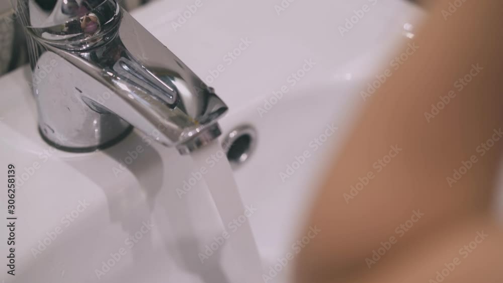 cute little girl washes hands and face with clean water at ceramic sink in light bathroom at home closeup cute little girl washes hands and face with clean water at ceramic sink in light bathroom at home closeup