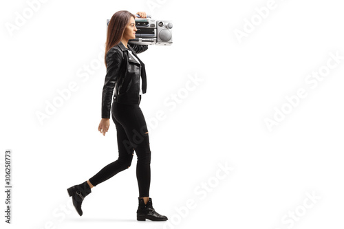 Young female carrying a bombox on her shoulder and walking photo