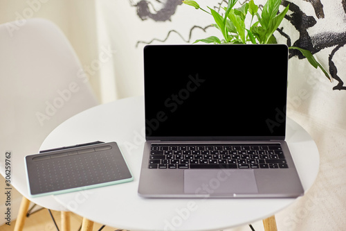 Laptop with a graphics tablet on a table in a cafe. 