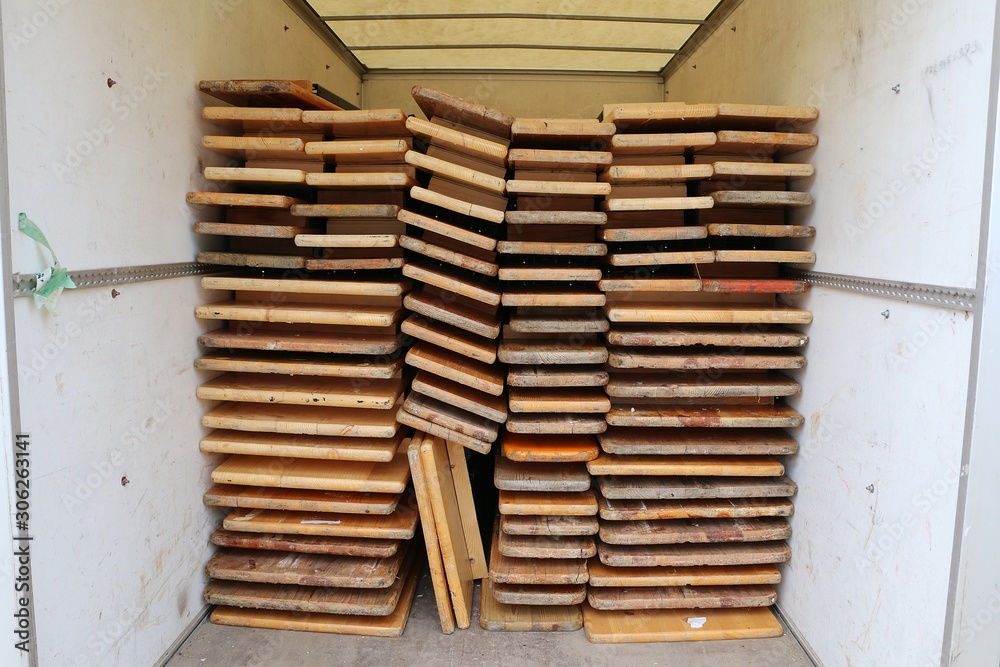Folded wood party tables and benches stacked in the trailer Folded wood party tables and benches stacked in the trailer