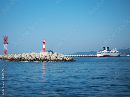 Red lighthouse with birds on a pier in the sea © jockermax3d