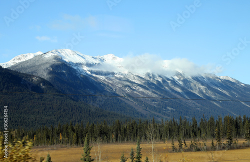 The wonderful train journey from Jasper to Vancouver in British Columbia, Canada in Autumn. With train, trees, foliage and snow capped mountains