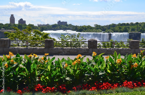 contrast of a beautiful garden facing Niagara Falls from the Canadian side and the view of the USA in the background