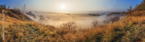 Autumn sunrise landscape, panorama, banner - view of a river valley covered with fog in the light of the sunrays, the northeast of Ukraine