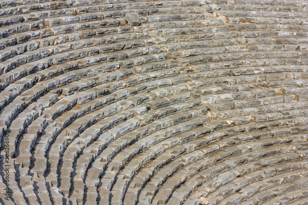 Mediterranean cityscape, background - view of the spectator seats in the theater of the ancient city of Myra, near the Turkish town of Demre, Antalya Province in Turkey Mediterranean cityscape, background - view of the spectator seats in the theater of the ancient city of Myra, near the Turkish town of Demre, Antalya Province in Turkey