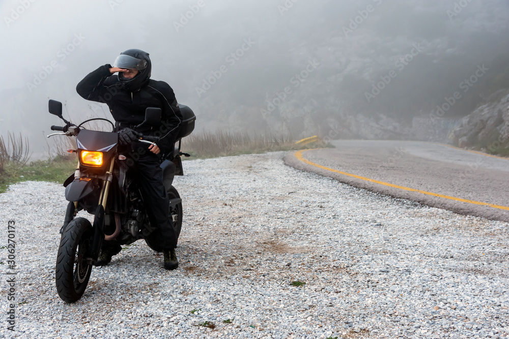 Naklejka premium Rider trying to see through the fog on an adventure ride on the mountains