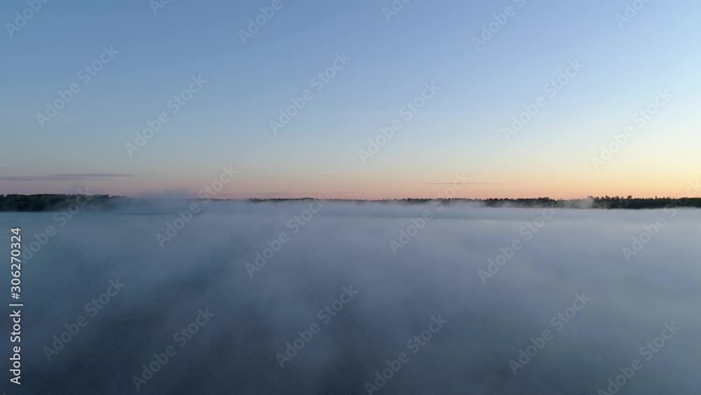 4K aerial reverse flight over a fog covered lake on a misty fall morning in Northwest Ontario, Canada. 4K aerial reverse flight over a fog covered lake on a misty fall morning in Northwest Ontario, Canada.