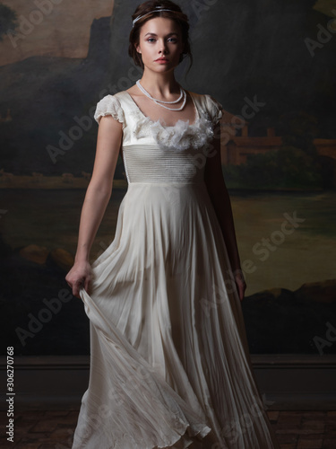 Photography Beautiful young woman in a white long dress in the style of the 19th century