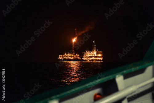 Night view of FPSO tanker vessel near Oil Rig. Offshore oil and gas industry. View from vessel deck photo