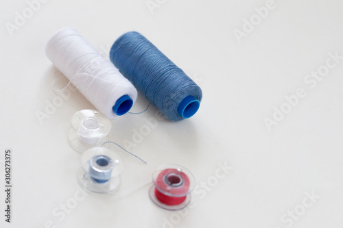 Sewing accessories on a light background close-up. Multi-colored spools of thread