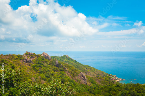 Natural Landscape View of Stone Mountain and Tropical Beach against Blue Sky and Clouds