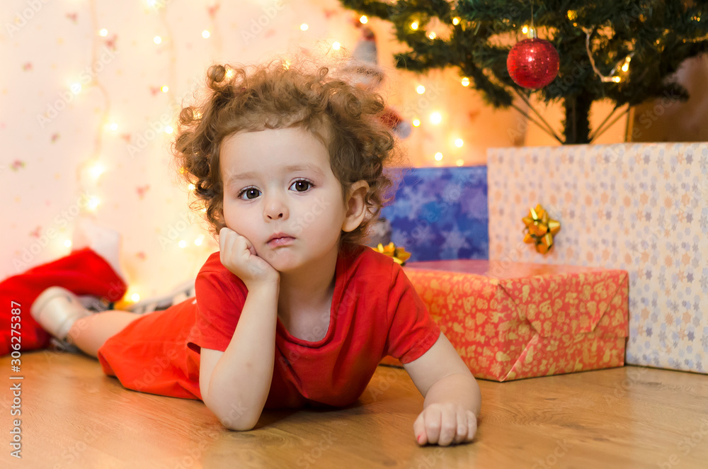 upset little girl waiting for a surprise. no christmas gifts for baby. A pensive little girl is waiting for Santa Claus and the promised gift. upset little girl waiting for a surprise. no christmas gifts for baby. A pensive little girl is waiting for Santa Claus and the promised gift.