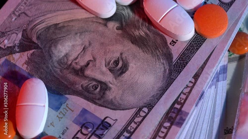 100 dollar bills and drugs with pills spinning on the table