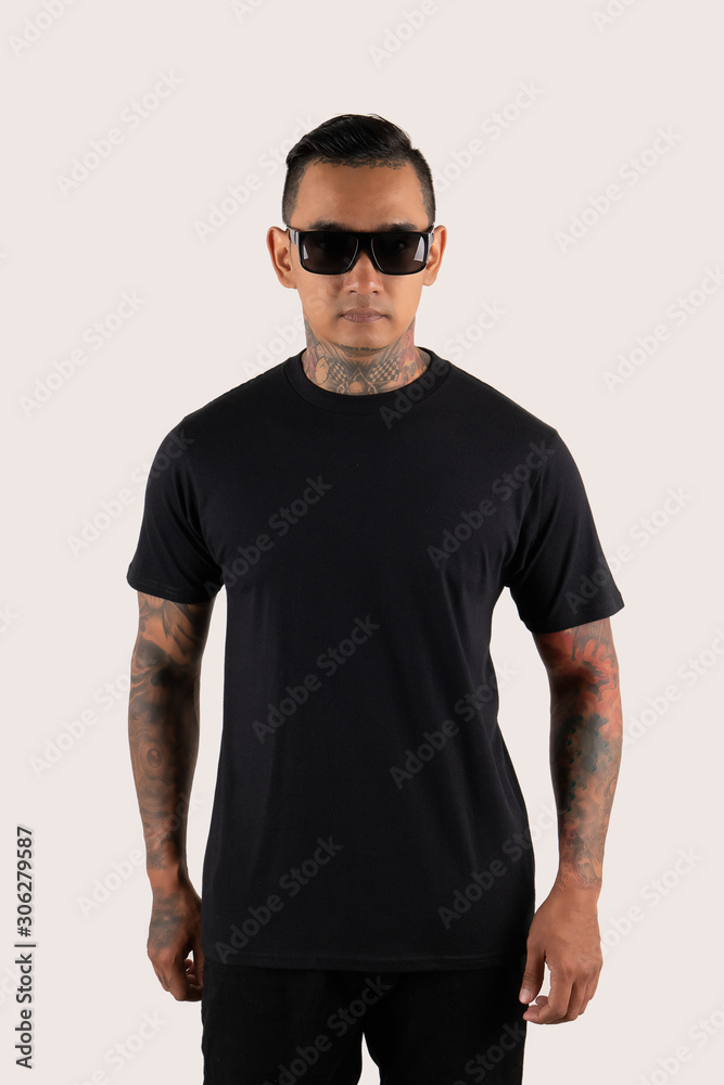 Man with tattoo wearing black t-shirt isolated on plain background