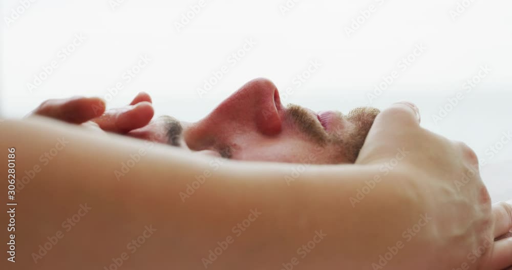 Close up of an young handsome man is receiving a facial massage and spa treatment for perfect skin in a luxury wellness center. Close up of an young handsome man is receiving a facial massage and spa treatment for perfect skin in a luxury wellness center.