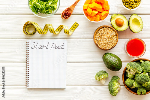 Diet program mockup. Start diet text in notebook near vegetables on white wooden background top view