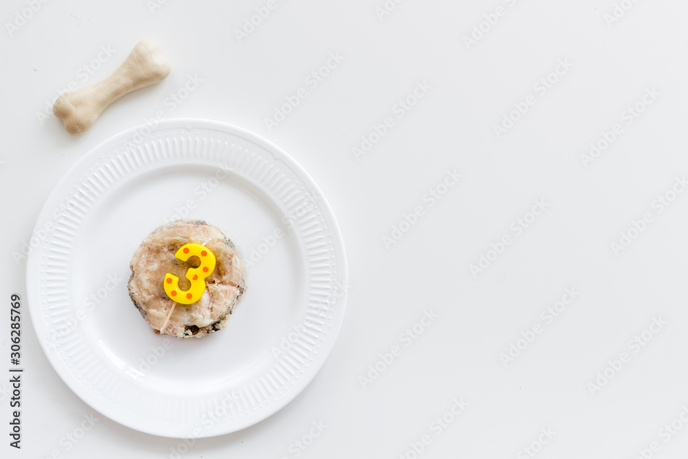 Birthday party for puppy concept. Dog feed, candle in shape of number three, bones on white background top-down copy space Birthday party for puppy concept. Dog feed, candle in shape of number three, bones on white background top-down copy space