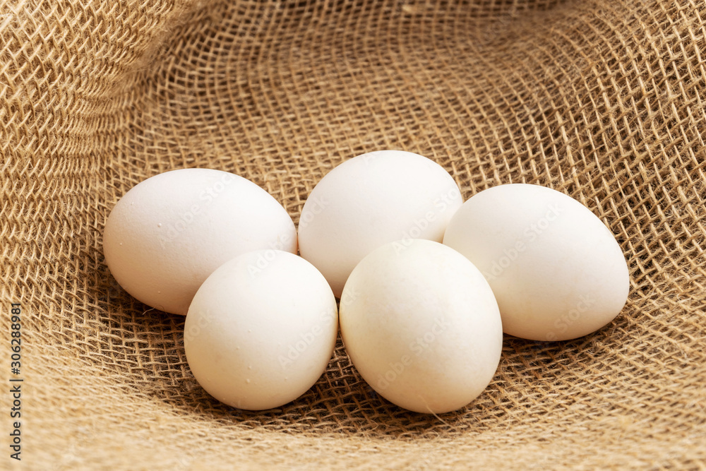 Chicken eggs lie on a background of burlap. Chicken eggs lie on a background of burlap.