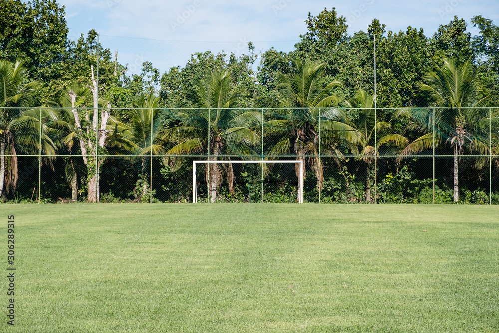 Obraz premium soccer posts in park, field is partially covered in the shadow. Trees in the background are in the sun. Rio de Janeiro, Brazil.