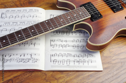 Electric guitar and chord book on a wooden texture