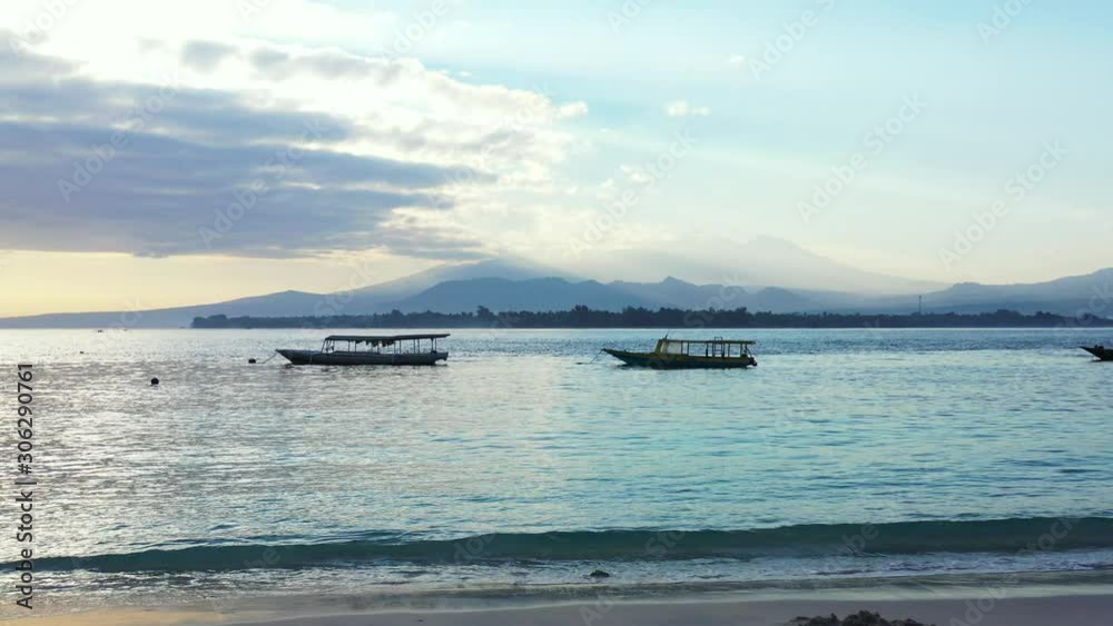 Dominican republic, Early morning on the tropical island. Boats floating on the sea, sky with clouds covering distant mountains Dominican republic, Early morning on the tropical island. Boats floating on the sea, sky with clouds covering distant mountains