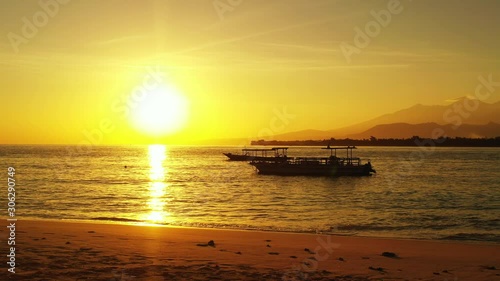 golden sun over the tropical sea and boats, mountain island in the background photo
