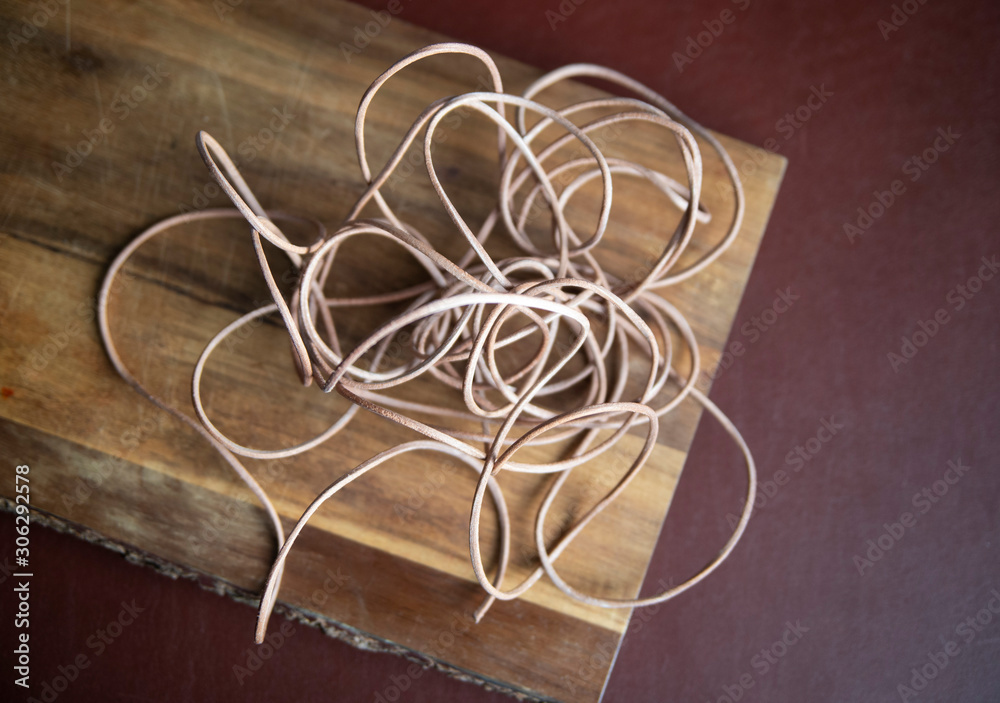 leather cord on wooden background leather cord on wooden background