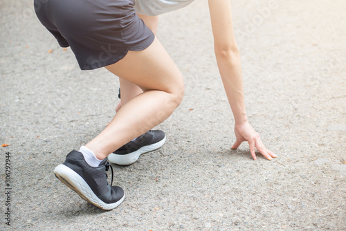 Cropped shot view of athlete runner woman in start position ready for sprint. Conceptual of sport and exercise workout.