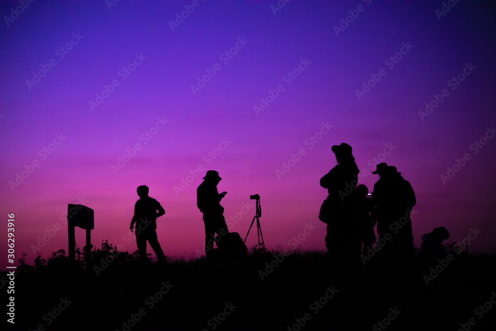 silhouettes of people on sunset background of the mountains